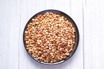 Processed pea nuts in a bowl on table top down .