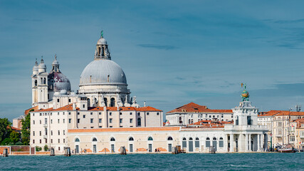 Panoramic view over Grand Canal with Basilica di Santa Maria della Salute, in Venice historical downtown, Italy, at sunny warm day and blue sky.