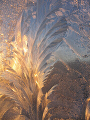Beautiful ice pattern and sunlight closeup on window glass