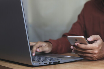 young man working on laptop in modern kitchen, checking email in morning, writing message in social network, happy young male using internet banking service, searching information
