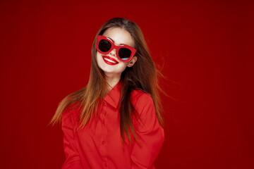 attractive woman in red shirt sunglasses fashion red background