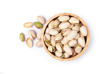 Pistachio nuts in wooden bowl isolated on white background. Top view. Flat lay.