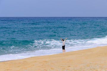 砂浜に押し寄せる波を楽しむ少女