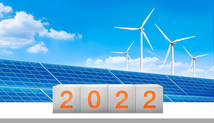 The year 2022 in concrete and clean energy, solar cell, Wind turbine in background. starting new...