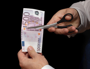 Five hundred Euros are cut in the hands of a man
