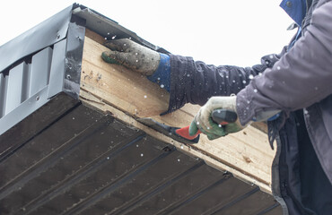 A worker assembles the roof of a house with an ax. Technologies