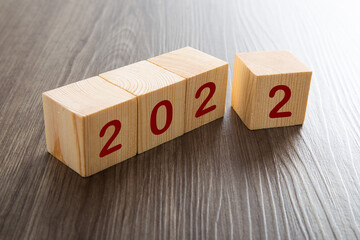 woodblocks cubes with a number 2022 wooden background.
