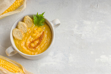 Healthy diet. Delicious creamy corn soup on a light background. Food for vegans and vegetarians. Copy space