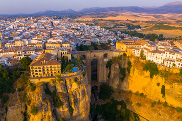 Ronda, Spain. Aerial evening view of New Bridge over Guadalevin River in Ronda, Andalusia, Spain. View of the touristic city with arena at the background © Madrugada Verde
