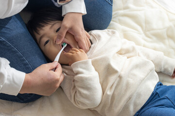 母親に歯を磨いてもらっている赤ちゃん（1歳4か月、女の子、日本人）