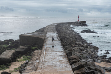 Lonely woman walking towards a lighthouse