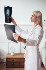 Female trauma surgeon examines skull scans in office