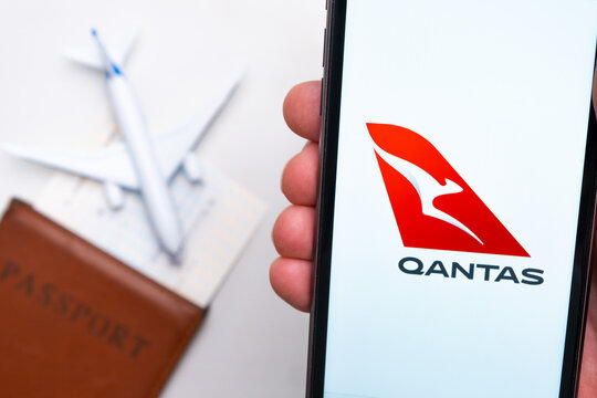 Qantas Airline logo on the mobile phone screen with a plane, passport and boarding pass on the background. The concept of the airlines mobile application. November 2021, San Francisco, USA
