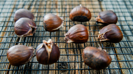 Chestnuts on cooling screen on rustic table side view