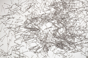 A lot of sewing pins on white background. 