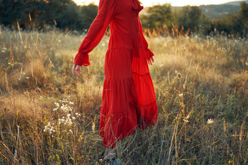woman in red dress in the field walk freedom landscape