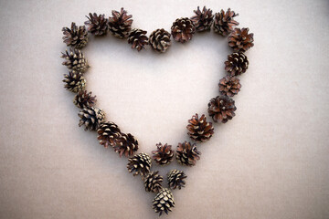 Cones in the shape of a heart on a cardboard isolate. New Year 's background . Pine cones.