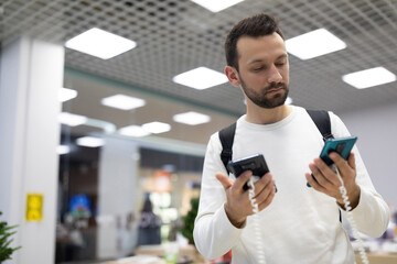 Photo of young handsome doubtful thinking brunette male person with stubble in a white sweatshirt...