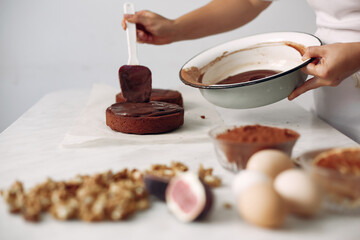 Chef spreads the cake with chocolate glaze.