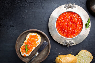 Delicious red caviar in vintage plate, top view, dark background - obrazy, fototapety, plakaty