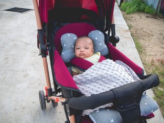 Asian male baby of Thai nationality sitting in a wheelchair