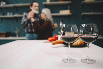 Smiling senior couple dancing in modern kitchen