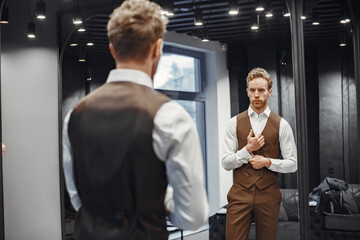 Handsome man with beard choosing jacket in a shop