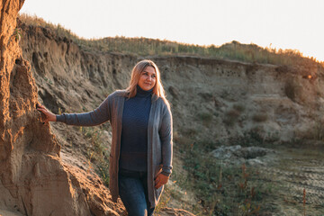 Beautiful plus size blonde girl is resting in nature. autumn day