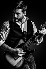 Hombre elegante en concierto tocando la guitarra electrica. Fotografía en blanco y negro