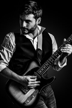 Hombre elegante en concierto tocando la guitarra electrica. Fotograf&iacute;a en blanco y negro