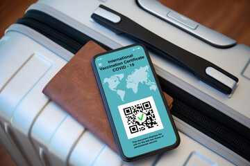 phone with international vaccination certificate covid 19 background suitcase