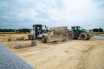 Niveleuse et tracteur benne chargeur sur un chantier de terrassement