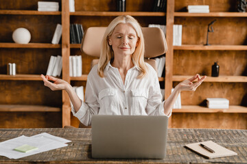 Caucasian concentrated mature middle-aged businesswoman ceo boss mediating at work place, feeling...