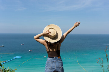 Women tourist standing on view point with sea and sky background at Koh Lan beach in summer, Thailand.