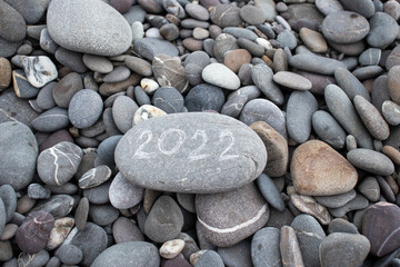 Fototapeta na wymiar stone with 2022 inscription by the sea