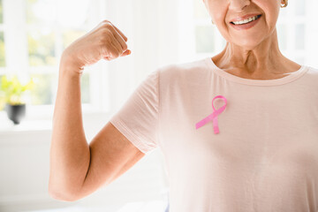 Mature senior elderly strong woman in pink t-shirt with pink ribbon supporting fighting for breast...