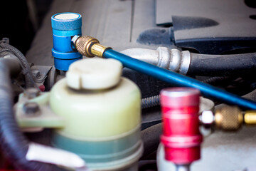 Servicing car air conditioner in vehicle service or repair workshop close-up