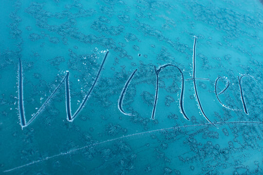 the inscription winter on the ice on the glass of the car.