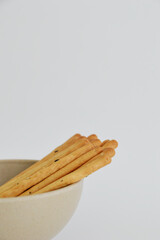 Korean vegan sesame sticks in a bowl against white background