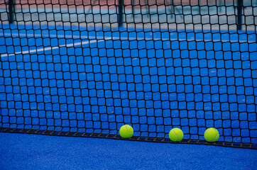 paddle tennis court, three balls by the net