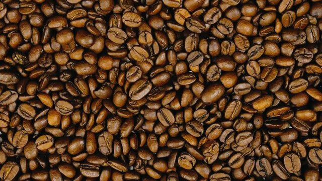 The coffee beans spin rotate quickly fast fly, dispart, splash to the sides with centrifugal coriolis force. Coffee beans twist, create pattern.