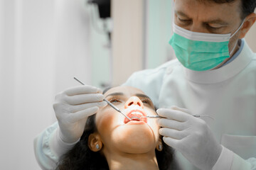 Obraz na płótnie Canvas Dental examination of a young girl patient in dental clinic,Teeth health concept.