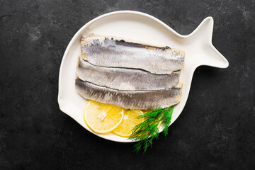 Delicious appetizer. Fillet of salted herring with lemon slices and dill. Healthy Fish Rich in Fish...