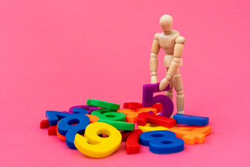 Wooden mannequin with a colored numbers on red background