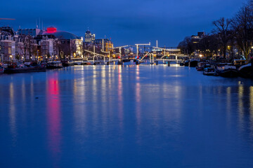 City scenic from Amsterdam at the river Amstel in the Netherlands at sunset