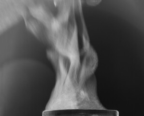 Movement of hot steam over a cup. Black and white. 