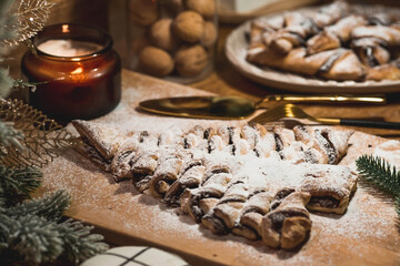 New Year's table. Treats for guests. Puff pastry cake with chocolate in the form of a Christmas tree on a wooden background. The concept of a family holiday. A copy of the space for the text.