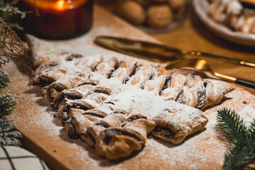 New Year's table. Treats for guests. Puff pastry cake with chocolate in the form of a Christmas tree on a wooden background. The concept of a family holiday. A copy of the space for the text.