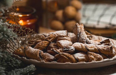 New Year's table. Treats for guests. Puff pastry cookies with chocolate in the form of bows on a wooden background. The concept of a family holiday. A copy of the space for the text.