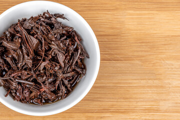 Close-up on a white bowl with used tea leaves.